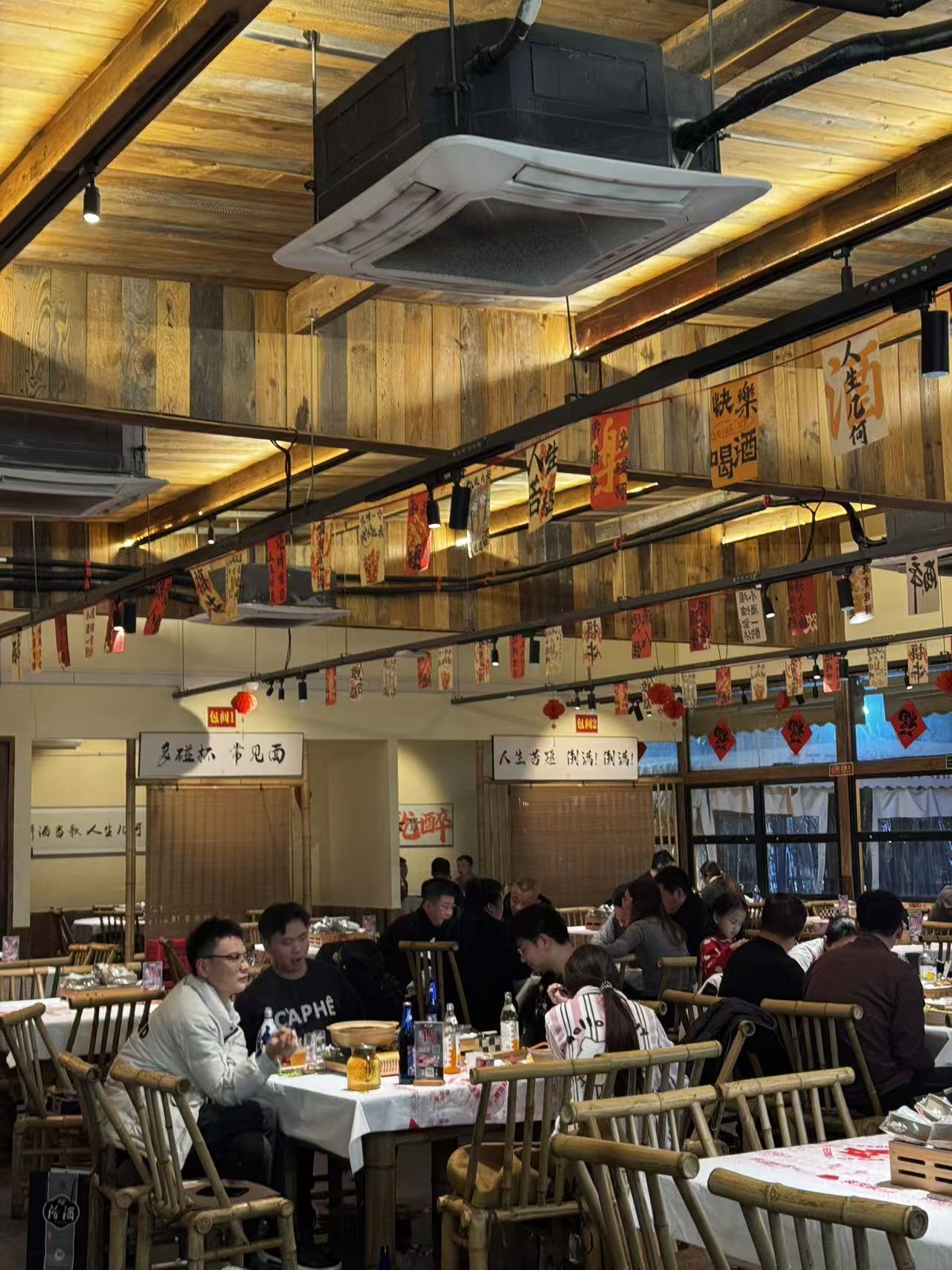 炙天天门店内的原木空间与围桌食客