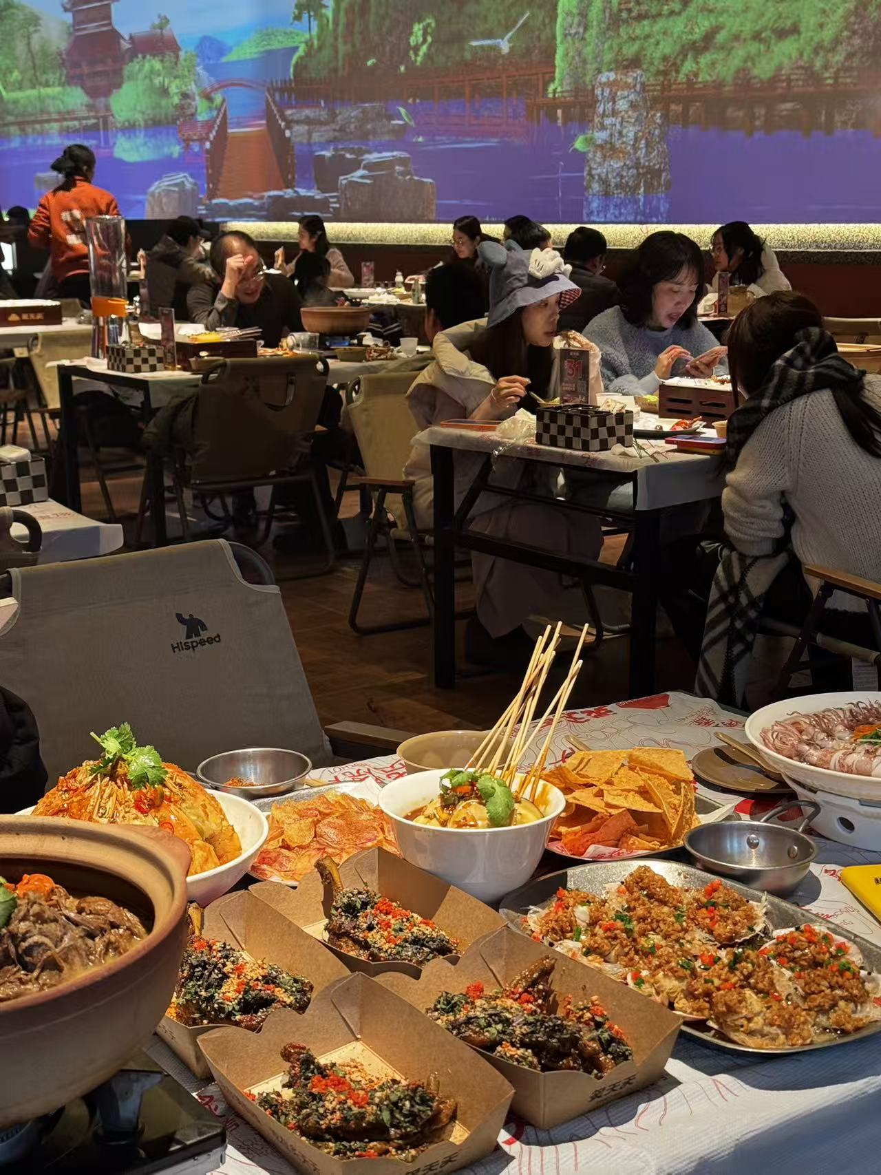 炙天天店内食客围桌，桌上摆满烧烤与海鲜