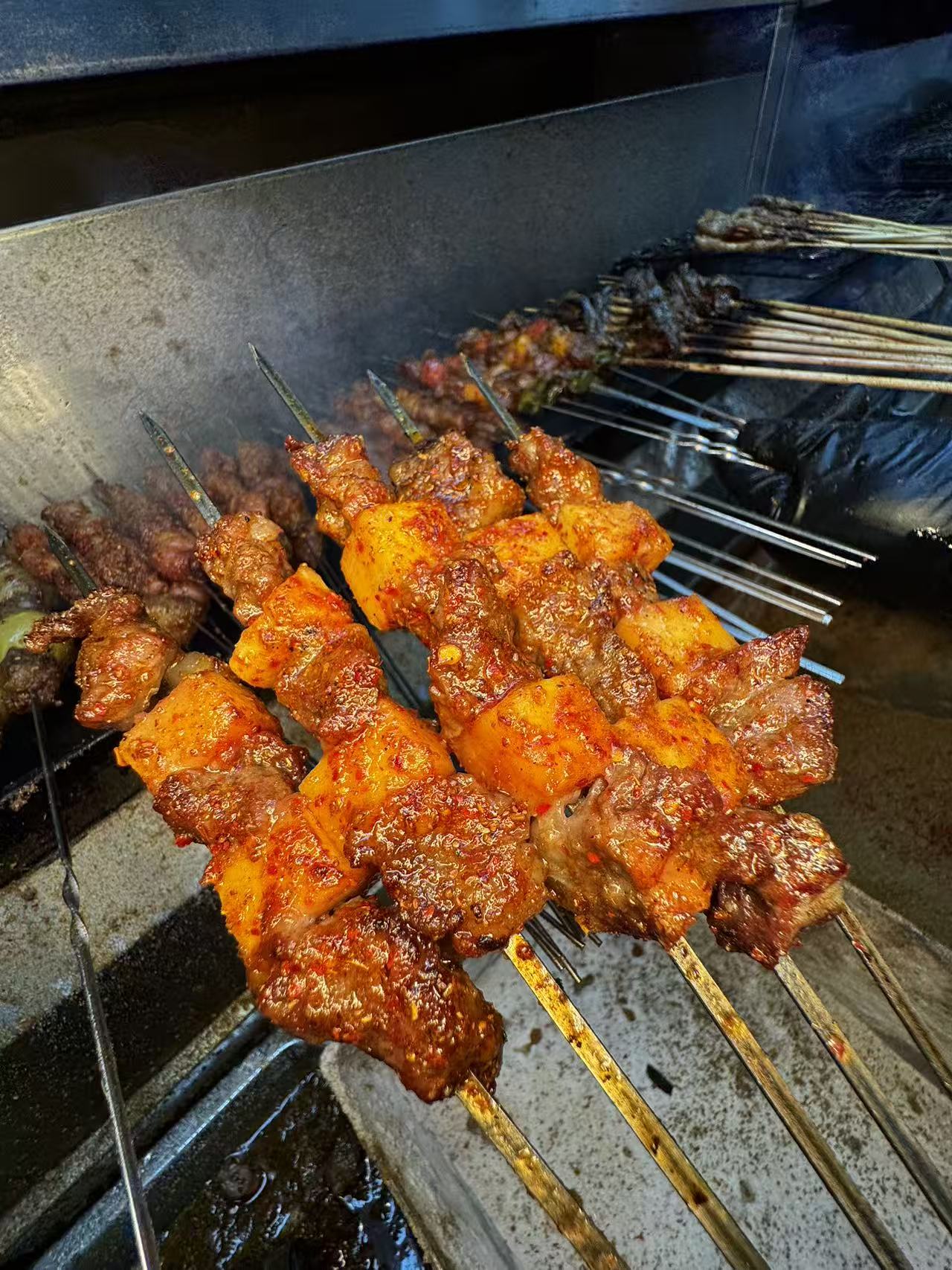 肉串与土豆在烤炉边出品的真实照片