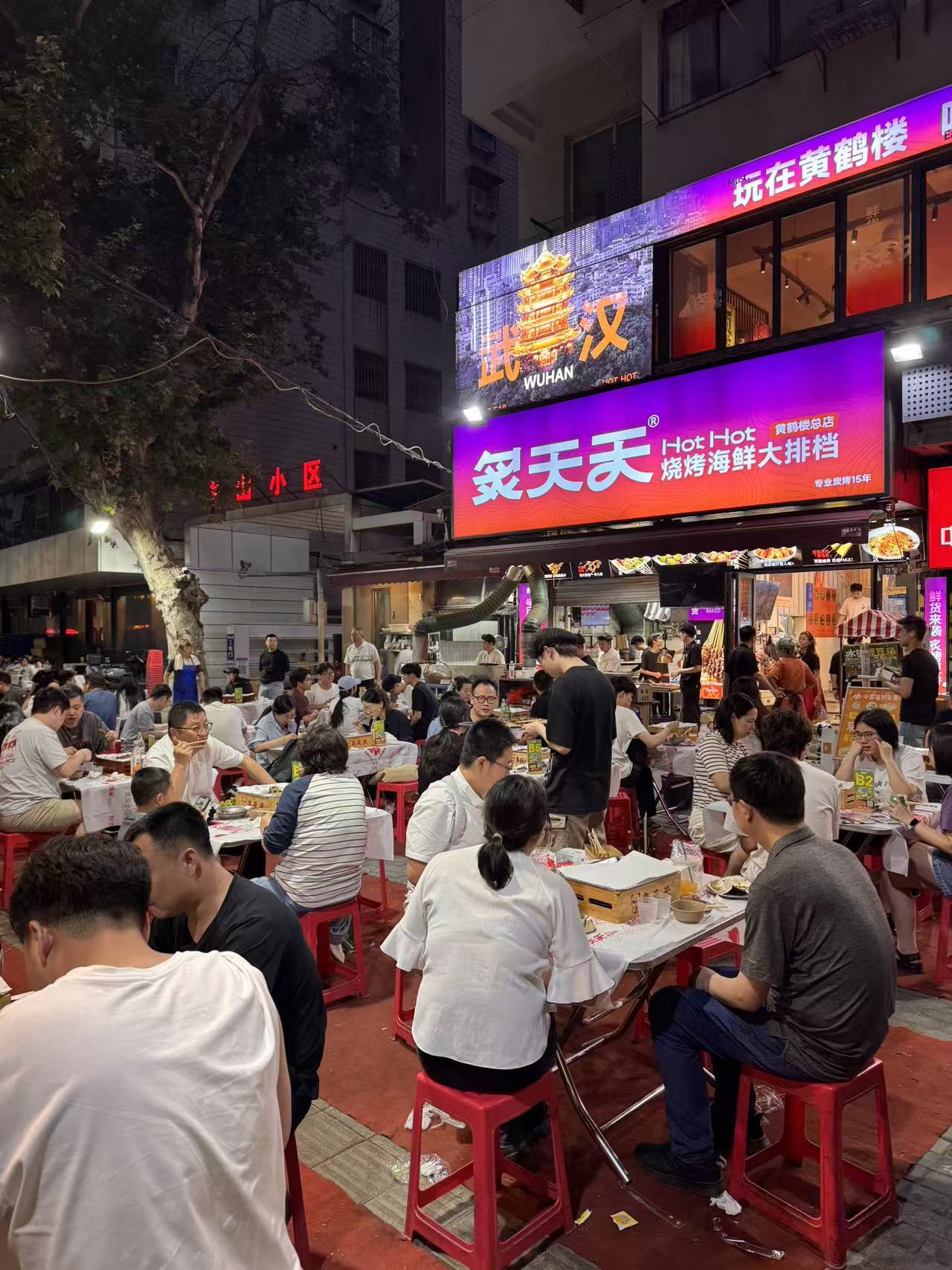 炙天天门店外坐满食客的武汉夜宵现场